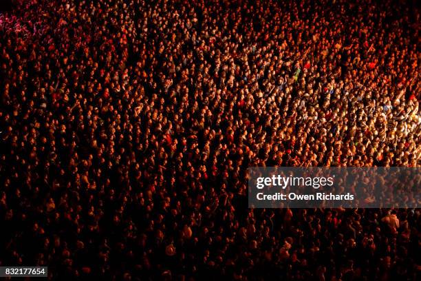 colourful light on large crowd of people - thousands of runners and spectators take to the streets for the london marathon stockfoto's en -beelden