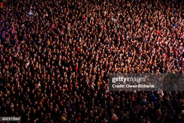 colourful light on large crowd of people - concert audience stock-fotos und bilder