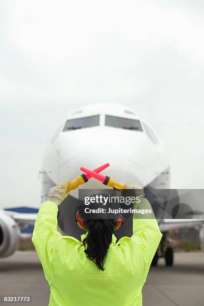 airport worker directing jet - airport tarmac stock pictures, royalty-free photos & images