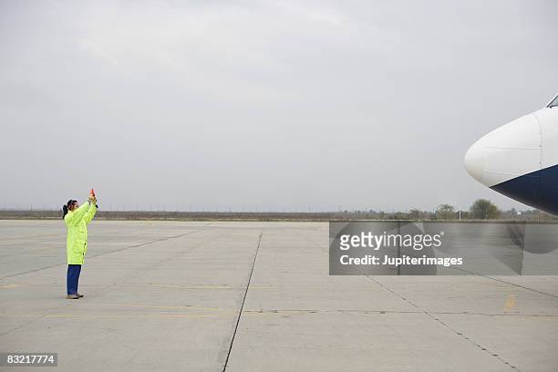 airport worker directing airplane - airport tarmac stock pictures, royalty-free photos & images