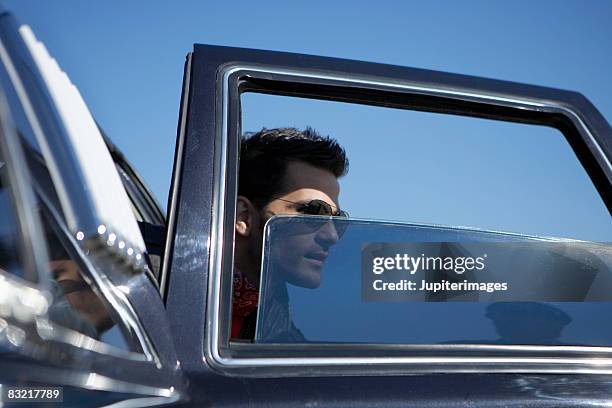 man exiting car - tinted window stock pictures, royalty-free photos & images