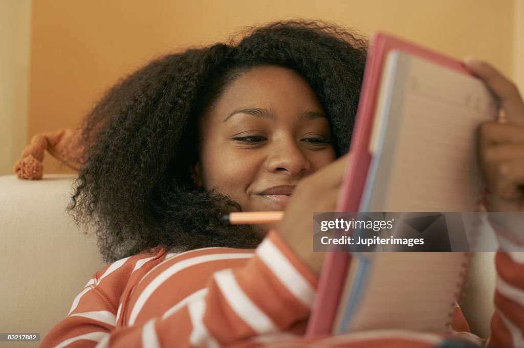 Teenage girl writing in notebook