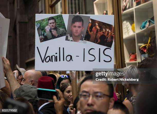 Anti-President Donald Trump protesters carry signs of right-wing activists outside of Trump Tower August 14, 2017 in New York City. Security...