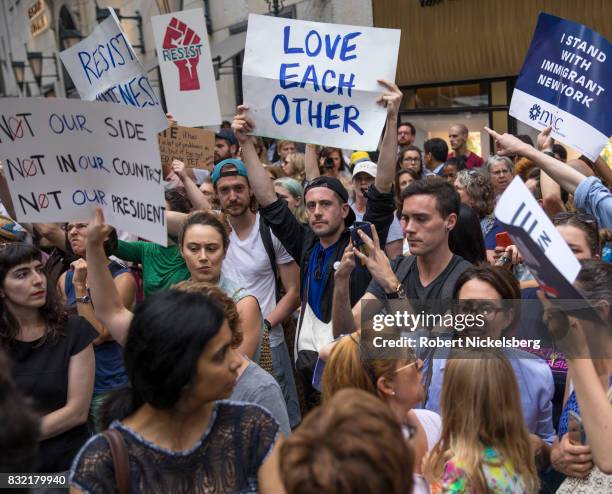 Anti-President Donald Trump protesters carry signs outside of Trump Tower August 14, 2017 in New York City. Security throughout the area is high as...