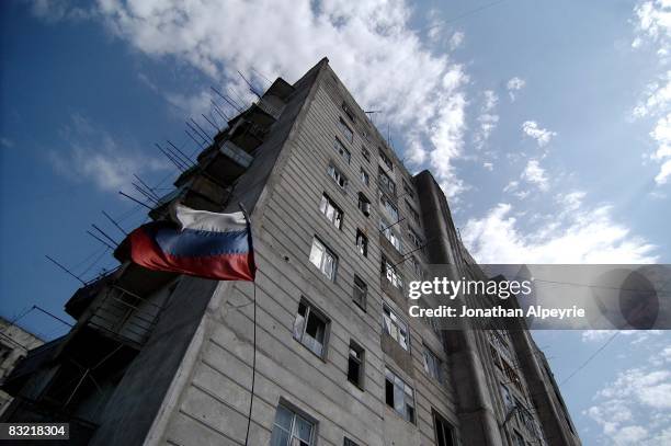 Russian Federation flag, attached to a parked APC, waves outside this 20-story building on August 15, 2008 in Tskhinvali, South Ossetia. Hundreds of...