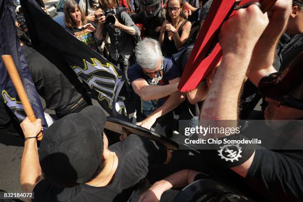 One of hundredes of white nationalists, neo-Nazis and members of the "alt-right" use wood shields and batons to beat a counter protester on the...