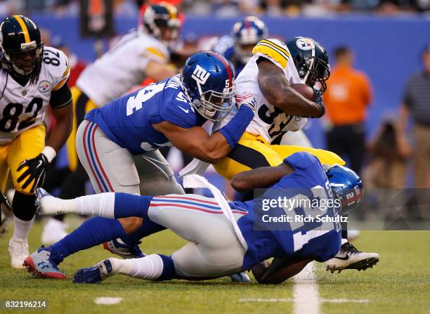 Fitzgerald Toussaint of the Pittsburgh Steelers is tackled by Olivier Vernon and Landon Collins of the New York Giants during an NFL preseason game...