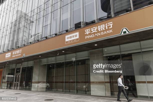 Pedestrian walks past a Ping An Bank Co. Branch, a unit of Ping An Insurance Group Co., in Beijing, China, on Wednesday, Aug. 9 2017. Ping An...