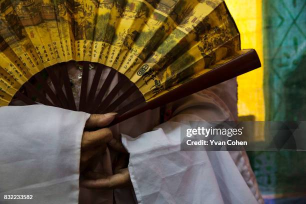 Chinese opera performer holds a fan backstage during a performance in the Chinatown area of Bangkok.