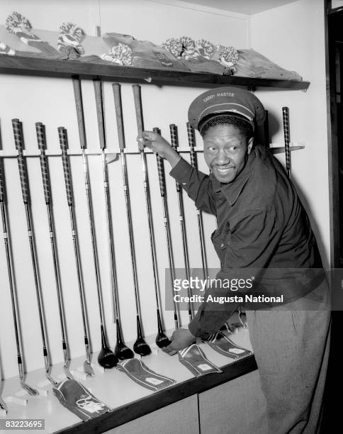 1950s: Caddie Master, John Henry "Leven" Williams adjusts the display of clubs during the 1950s Masters Tournament at Augusta National Golf Club in...
