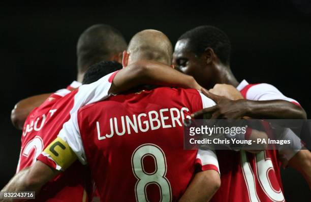 Arsenal players celebrate in a huddle after Mathieu Flamini's late winner confirms their progess into the latter stages of the Champions League,...