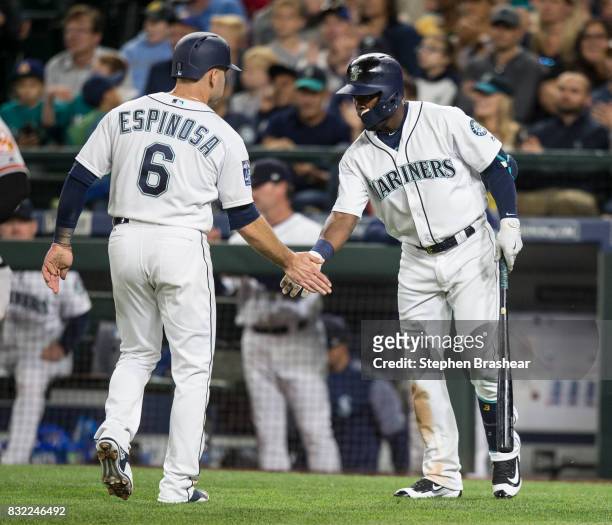 Danny Espinosa of the Seattle Mariners is greeted by Guillermo Heredia of the Seattle Mariners after scoring a run on a hit by Jean Segura of the...