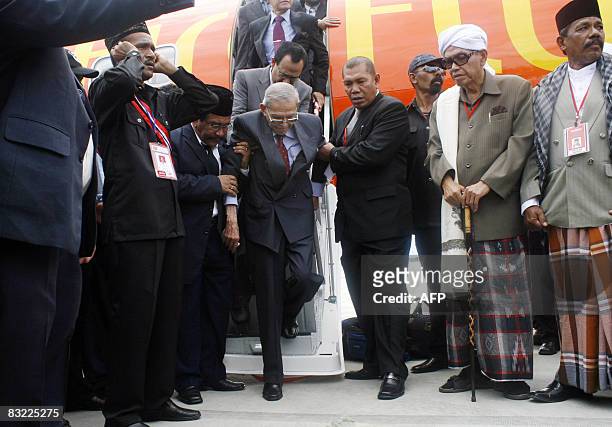 Free Aceh Movement founder Hasan di Tiro is helped as he disembarks from a plane shortly after arriving in Banda Aceh on October 11, 2008. The...