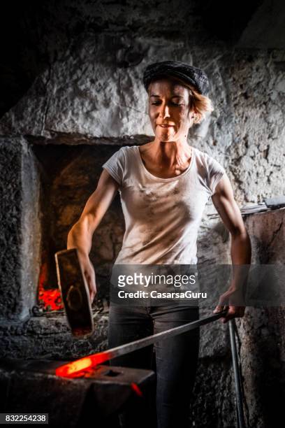 portrait of young blacksmith woman in blacksmith shop - anvil stock pictures, royalty-free photos & images