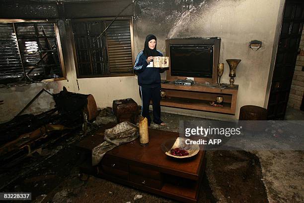 An Israeli Arab woman inspects the damage to her home in the mixed northern Israeli town of Acre on October 11 following another night of unrest...