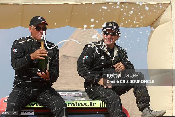 Auto category runners up Polish driver Patrick Sireyjol and his French team mate Paul Vidal of the Cummins team spray champagne as they celebrate on...