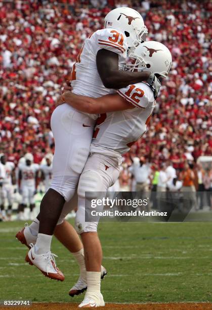 Quarterback Colt McCoy of the Texas Longhorns celebrates a touchdown with Cody Johnson against the Oklahoma Sooners during the Red River Rivalry at...