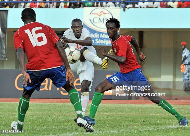 Senegalese forward Dia Salif Alassane vies with Gambian defenders Jameh Abdou and Sohna Ibrahima during their World Cup 2010 qualifying match at the...
