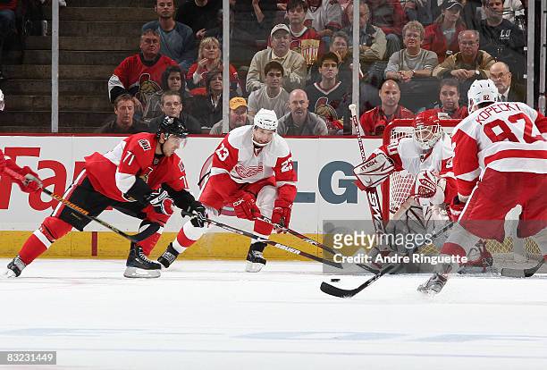 Nick Foligno of the Ottawa Senators drives the puck to the net against Brad Stuart and Chris Osgood of the Detroit Red Wings at Scotiabank Place on...