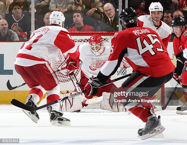 Chris Osgood of the Detroit Red Wings makes a stick save through traffic on a shot by Alexandre Picard of the Ottawa Senators at Scotiabank Place on...