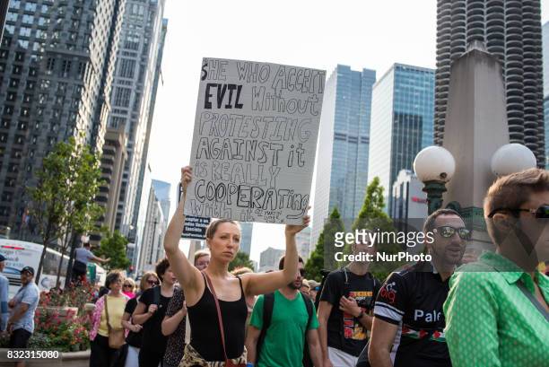 Demonstrator carries a sign with a Martin Luther King Jr. Quote near Trump International Hotel and Tower Chicago in solidarity with the victims of...