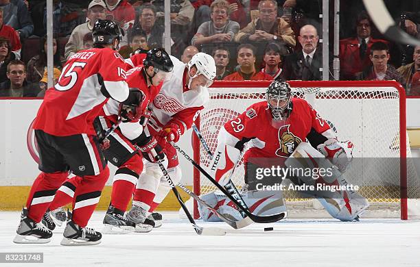 Marian Hossa the Detroit Red Wings drives to the net with the puck as Jason Spezza and Martin Gerber of the Ottawa Senators defend at Scotiabank...