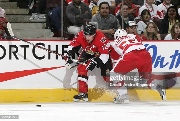 Mike Fisher of the Ottawa Senators battles along the boards for the puck against Niklas Kronwall of the Detroit Red Wings at Scotiabank Place on...