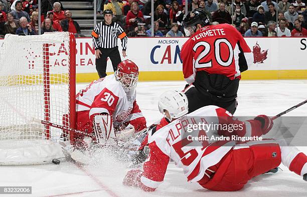 Antoine Vermette of the Ottawa Senators looks for a rebound as Chris Osgood of the Detroit Red Wings makes a save at Scotiabank Place on October 11,...