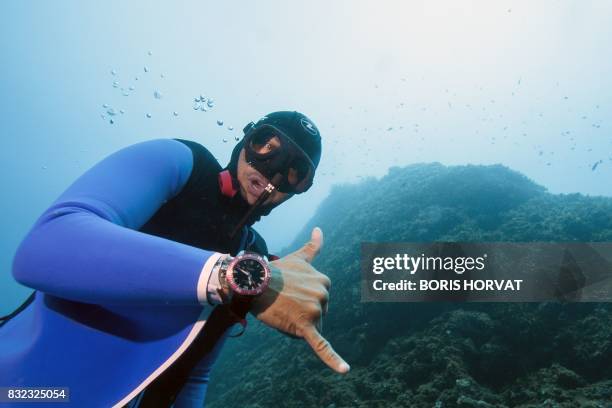 Monaco's freediver Pierre Frolla wearing a prototype of an ''Oceanwings' wetsuit gestures as he glides through the water on August 13, 2017 in the...