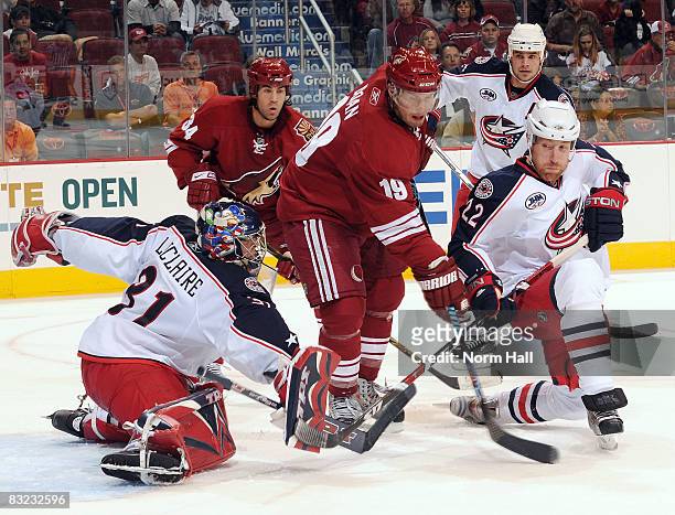 Pascal Leclaire of the Columbus Blue Jackets and Mike Commodore of the Columbus Blue Jackets stop Shane Doan of the Phoenix Coyotes from scoring...