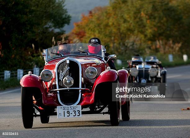 Classic car owners drive their vintage automobiles past the crowds during the 2008 La Festa Mille Miglia classic car rally at the Shiroishi Castle on...