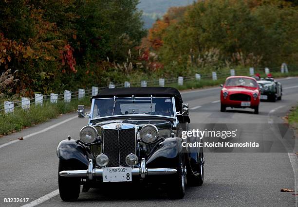 Classic car owners drive their vintage automobiles past the crowds during the 2008 La Festa Mille Miglia classic car rally at the Shiroishi Castle on...