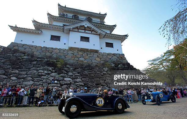 Classic car owners drive their vintage automobiles past the crowds during the 2008 La Festa Mille Miglia classic car rally at the Shiroishi Castle on...