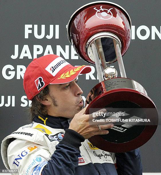 Spain's Fernando Alonso of Renault kisses the winner's trophy on the podium following his victory in Formula One's Japanese Grand Prix at the Fuji...