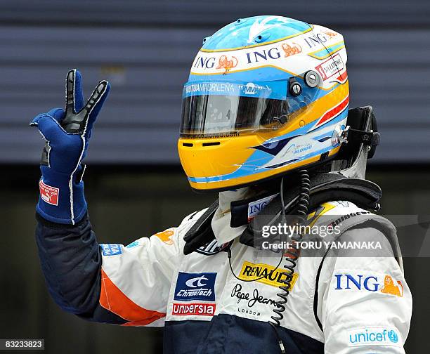 Spain's Fernando Alonso of Renault flashes a victory sign just after his victory in Formula One's Japanese Grand Prix at the Fuji Speedway, some 100...