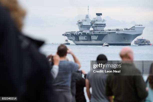 Members of the public gather to witness the arrival of the HMS Queen Elizabeth supercarrier as it heads into port on August 16, 2017 in Portsmouth,...