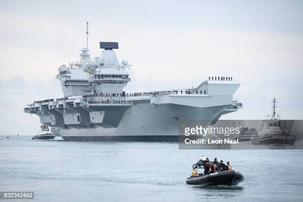 The HMS Queen Elizabeth supercarrier heads into port on August 16, 2017 in Portsmouth, England. The HMS Queen Elizabeth is the lead ship in the new...