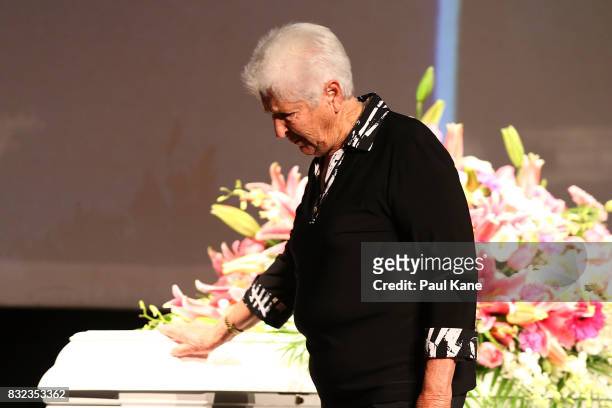 Dawn Fraser places her hand on the coffin after delivering a eulogy during the funeral service for Betty Cuthbert at Mandurah Performing Arts Centre...