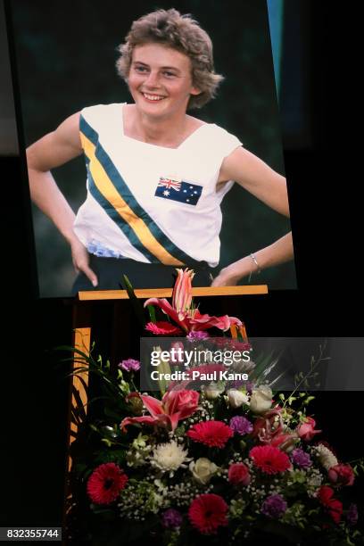 Floral and photographic tributes are seen on the stage during the funeral service for Betty Cuthbert at Mandurah Performing Arts Centre on August 16,...