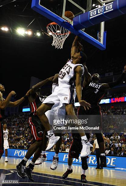 Brian Hamilton of New Jersey Nets jumps for the rebound with Dwyane Wade of the Miami Heat during the NBA preseason game as part of the 2008 NBA...