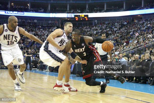 Dwyane Wade the Miami Heat drives around Brook Lopez and Vince Carter of the New Jersey Nets during the preseason game as part of the 2008 NBA Europe...
