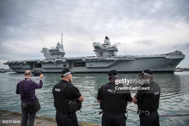 Armed police chat as HMS Queen Elizabeth sails into her home port of Portsmouth Naval Base on August 16, 2017 in Portsmouth, England. HMS Queen...