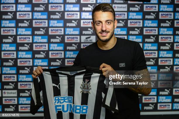 Joselu poses for photographs holding a NUFC home shirt at The Newcastle United Training Centre on August 14 in Newcastle upon Tyne, England.