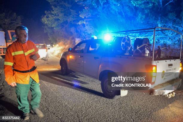 Volunteers work to extinguish a vast fire in Sila, with fire truck , in Calabria, southern Italy.