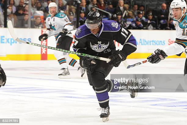 Wayne Simmonds of the Los Angeles Kings skates while being stick checked by Patrick Marleau of the San Jose Sharks on October 12, 2008 at Staples...