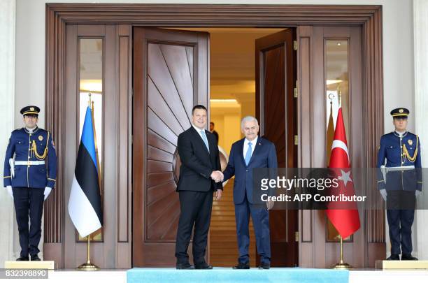 Turkish Prime Minister Binali Yildirim and Estonian Prime Minister Juri Ratas shake hands during an official welcoming ceremony prior to their...