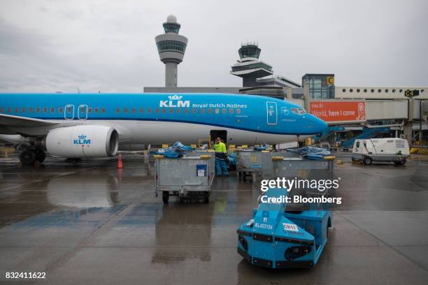 Passenger baggage is loaded onto an aircraft operated by KLM, the Dutch arm of Air France-KLM Group, on the tarmac at Schiphol airport in Amsterdam,...