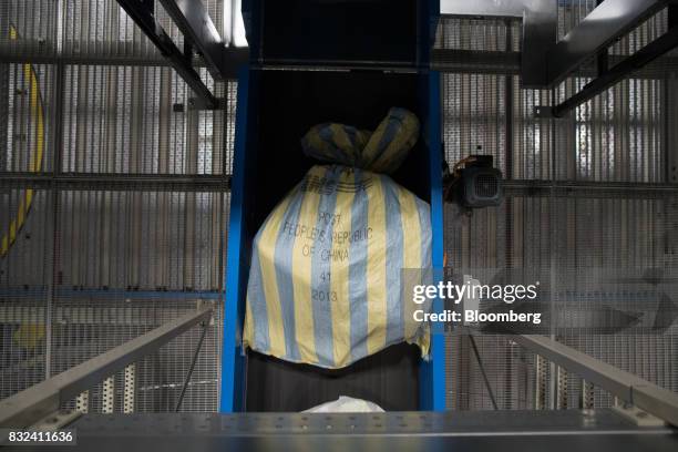 Mail sack marked "Post People's Republic Of China" passes along a conveyor belt inside the KLM Cargo center, operated by Air France-KLM Group, at...