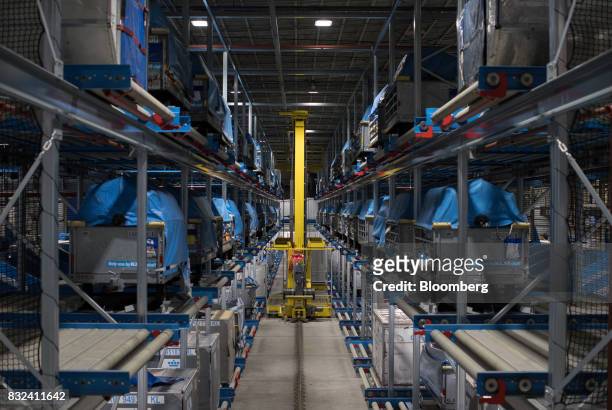 An unmanned mail sorting vehicle collects packages as cargo crates stand on shelving inside the KLM Cargo center, operated by Air France-KLM Group,...