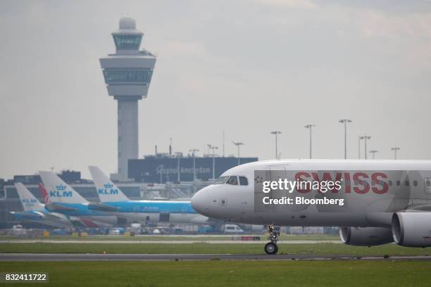 Passenger aircraft operated by Swiss International Air Lines Ltd. Taxis as KLM jets, operated by the Dutch arm of Air France-KLM Group, stand beyond...